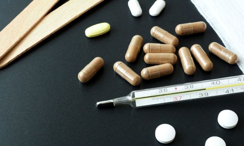 prikaz tableta i toplomera na crnom stolu